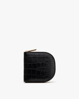 Small zippered wallet with a textured surface standing upright.