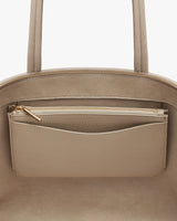 Close-up of a handbag with a zipper pocket on the exterior.