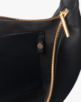 Close-up view of the open compartment of a bag with a zipper and a pocket.