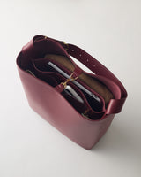Open tote bag with several compartments, holding a laptop and other items.