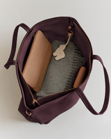 Open tote bag containing wallet, scarf, and small pouch.