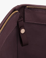 Interior view of a bag with a zipper and leather tab.