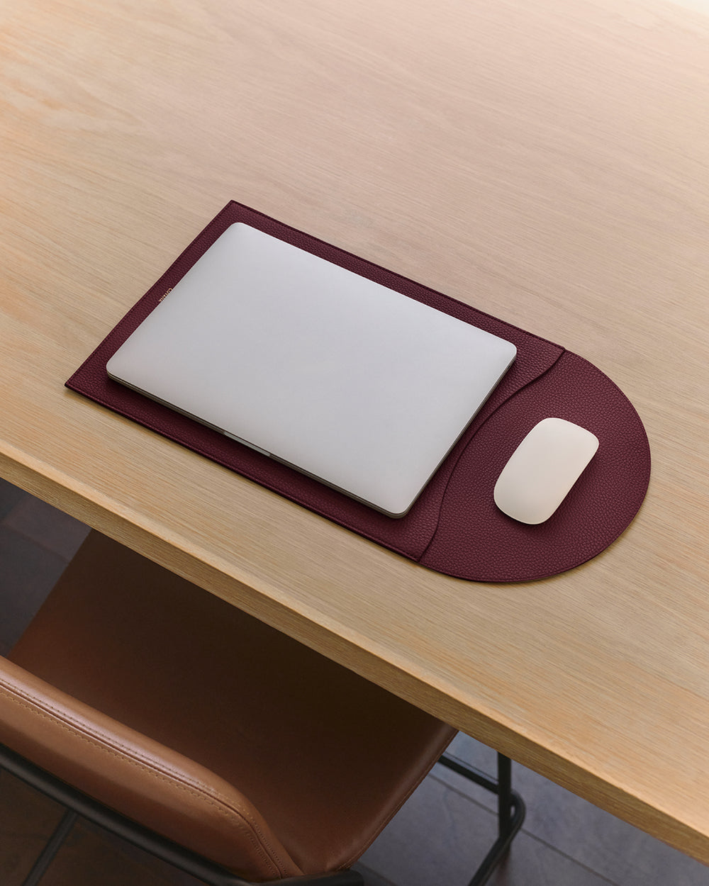 Laptop and mouse on a flattened laptop sleeve.