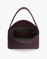 Open handbag with small pouch inside and a single strap.