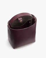 Open rectangular leather handbag with a top handle and visible interior.