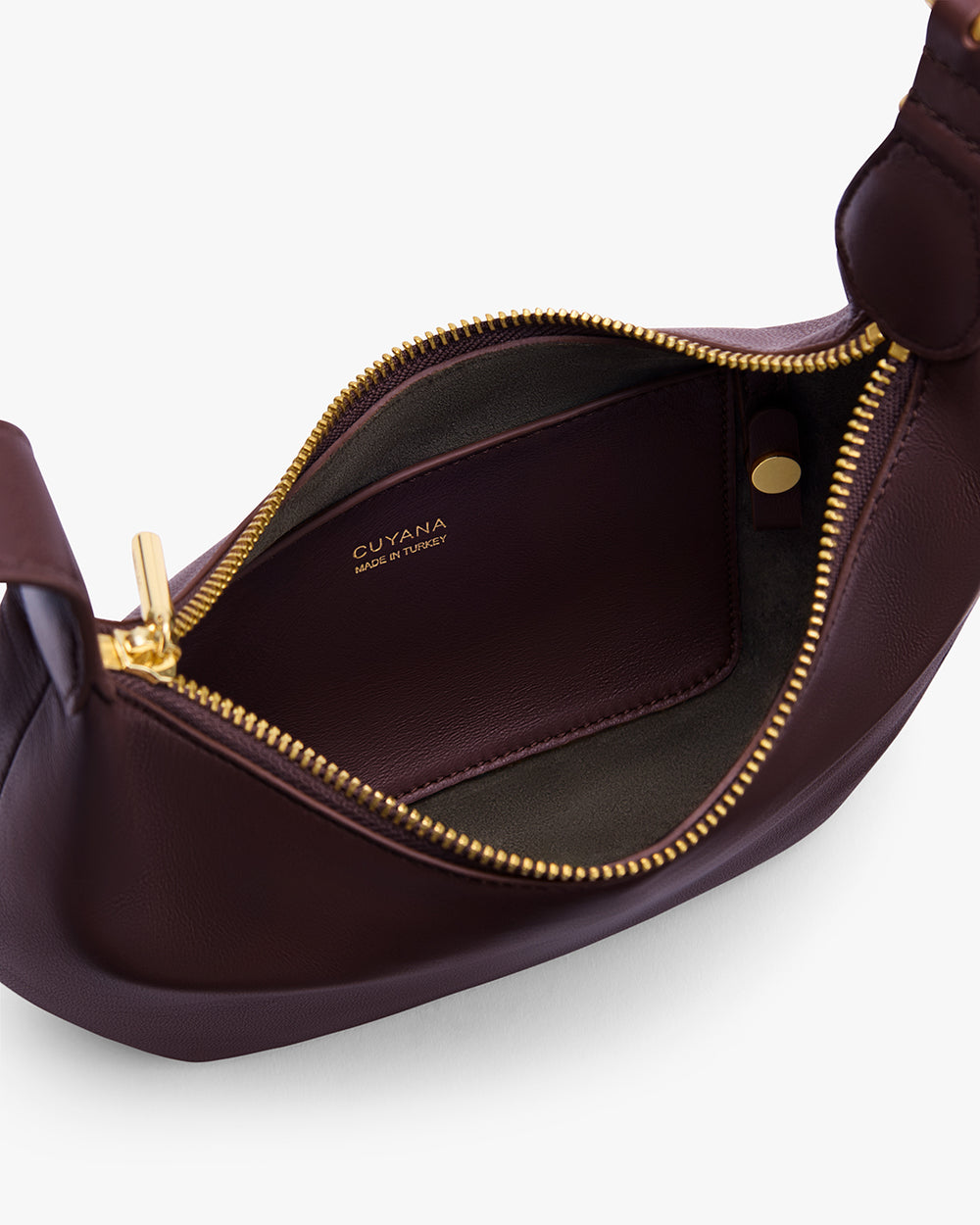 Open leather bag showing interior and zipper with brand name visible inside.