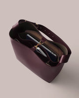 Open tote bag with contents including a laptop, notebook, and a rolled-up item