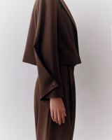 Person in side profile wearing a suit with long sleeves