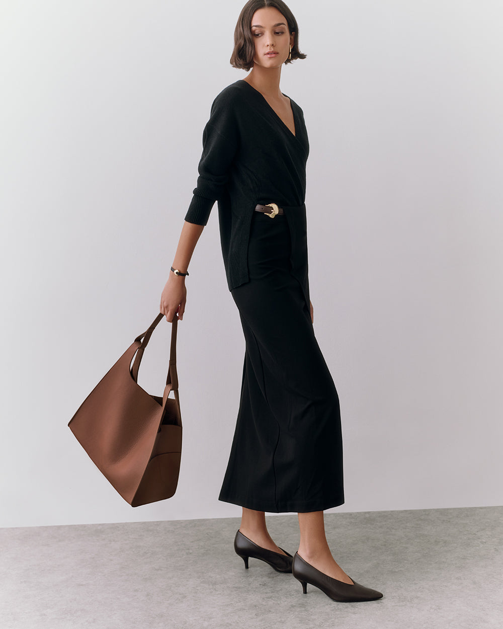 Woman in elegant outfit holding large handbag