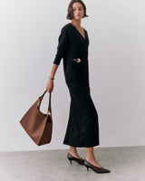 Woman in elegant outfit holding large handbag