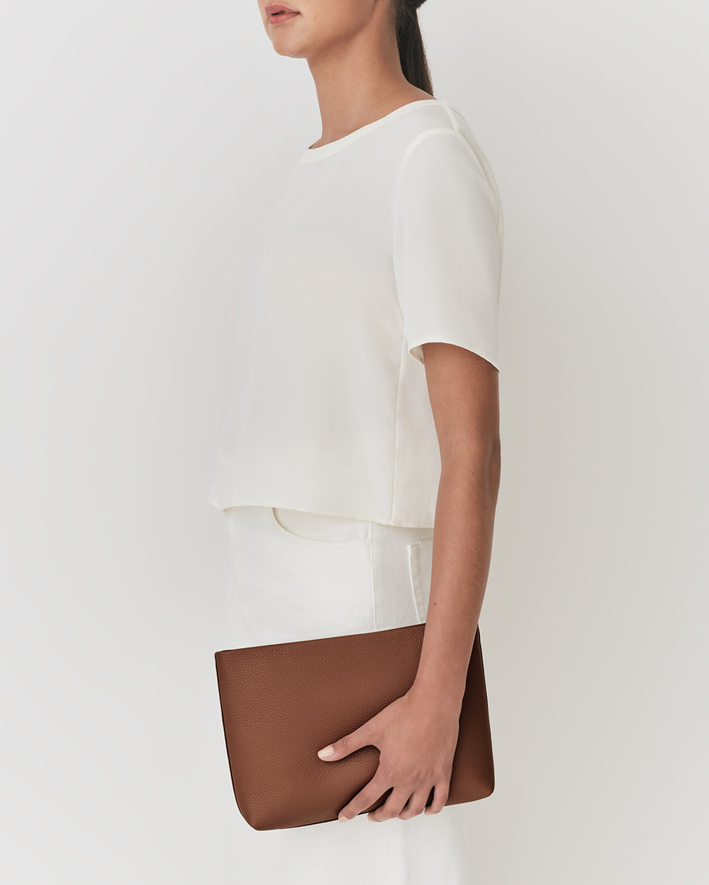 Person holding a rectangular pouch under their arm