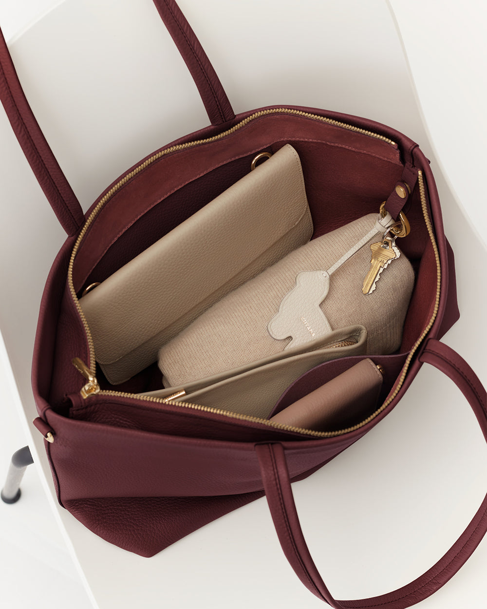 Open handbag with keys, pouches, and wallet inside.