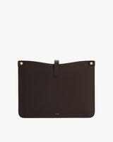 Leather laptop sleeve with a tab closure and two rivets at the top corners.
