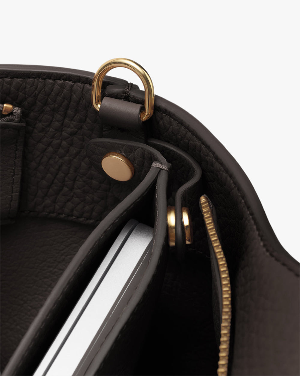 Close-up of a bag's interior with a detachable laptop sleeve inside and a zipper detail.