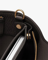 Close-up of a bag's interior with a detachable laptop sleeve inside and a zipper detail.