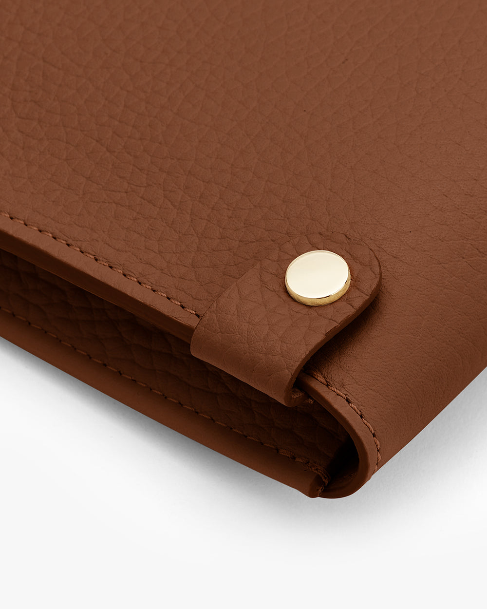 Close-up of a leather laptop skeeve corner with a button closure.