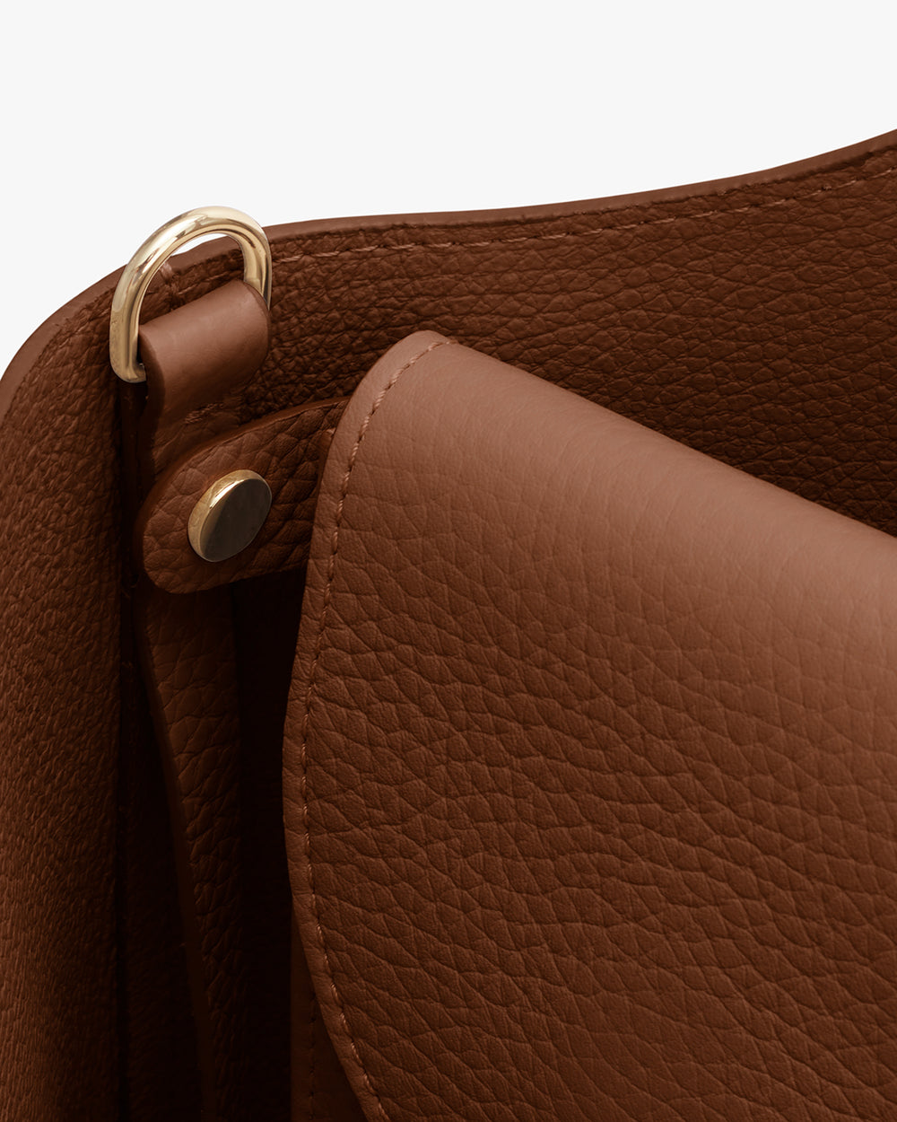 Close-up of textured leather laptop sleeve with metallic ring detail.