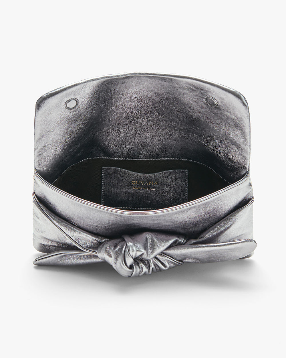 Open metallic clutch bag with a brand label inside.