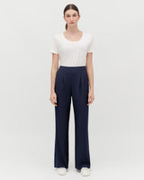 Woman standing in a t-shirt and trousers with hands at her sides