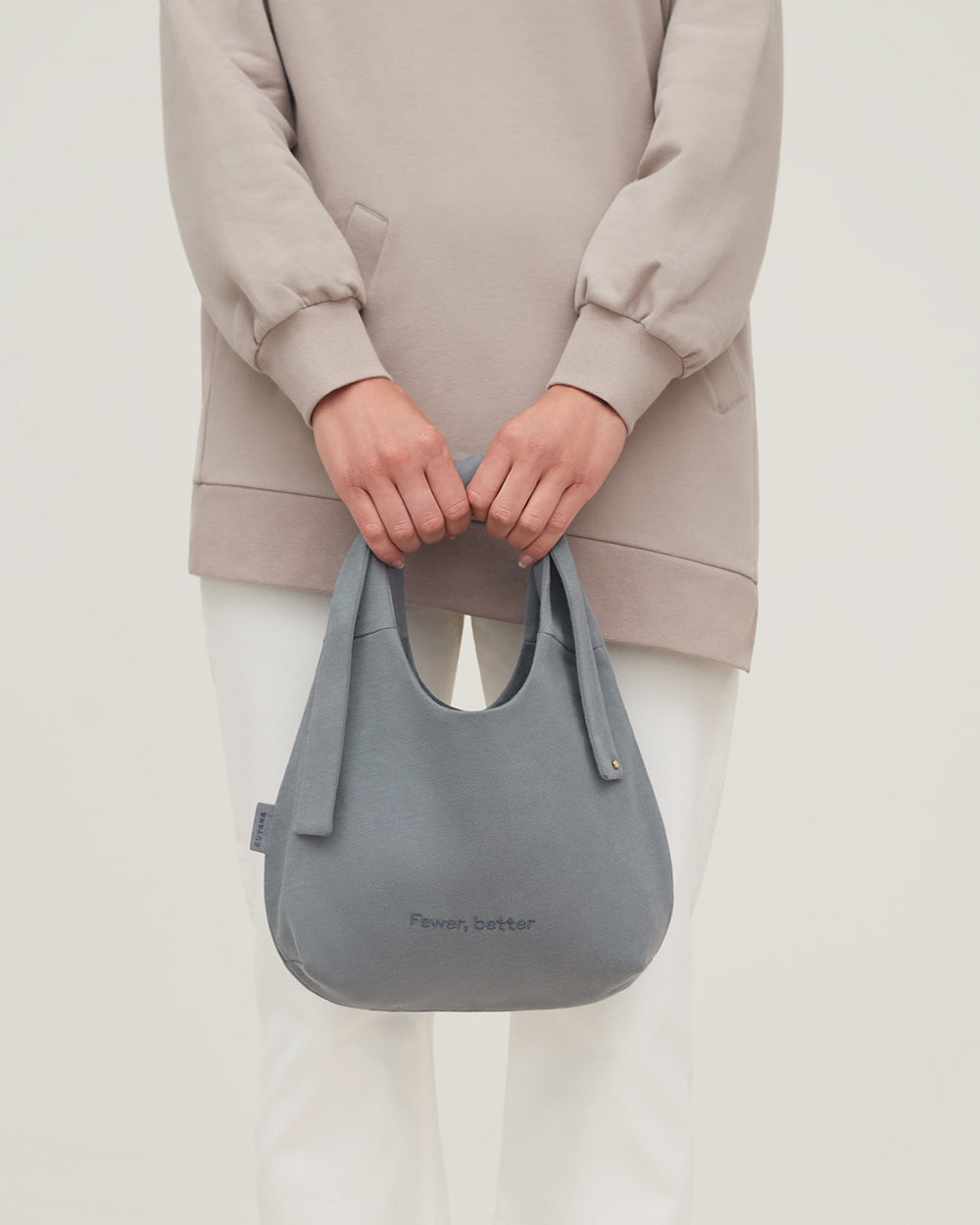 Person holding a handbag in front of them.