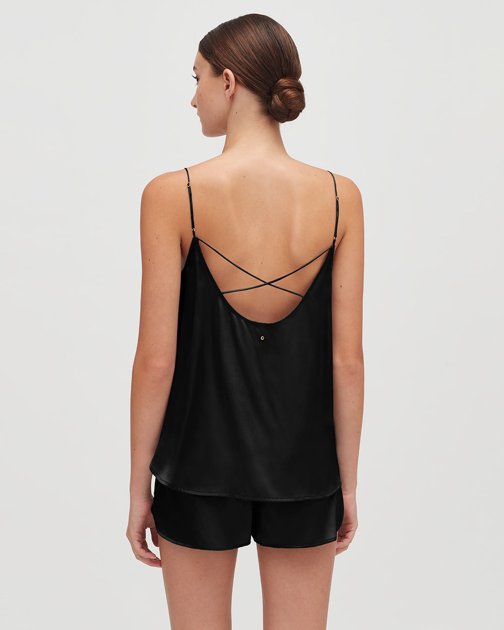 Woman seen from behind wearing a camisole with crossed straps.