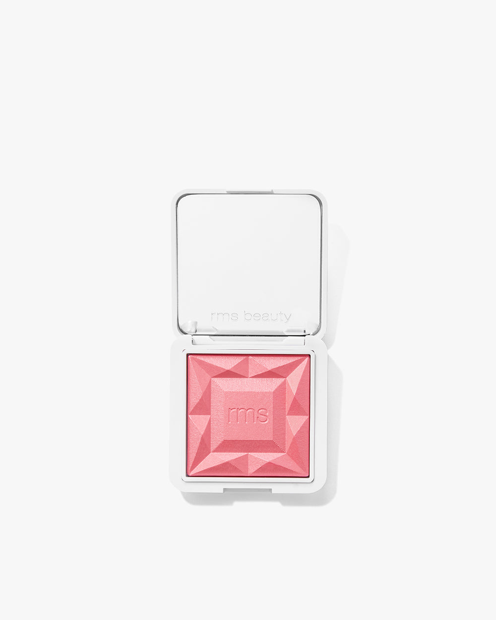 Makeup compact with raised geometric design on powder surface.