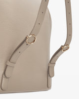 Close-up of a bag with adjustable straps and metal rings.