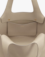 Open handbag with two handles and an exterior pocket.
