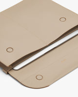Laptop in a textured sleeve with flap closure.