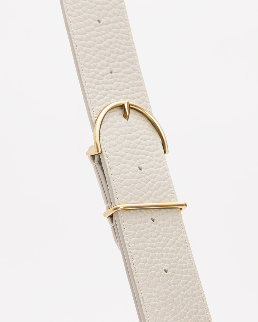Close-up of a textured belt with a metallic buckle.