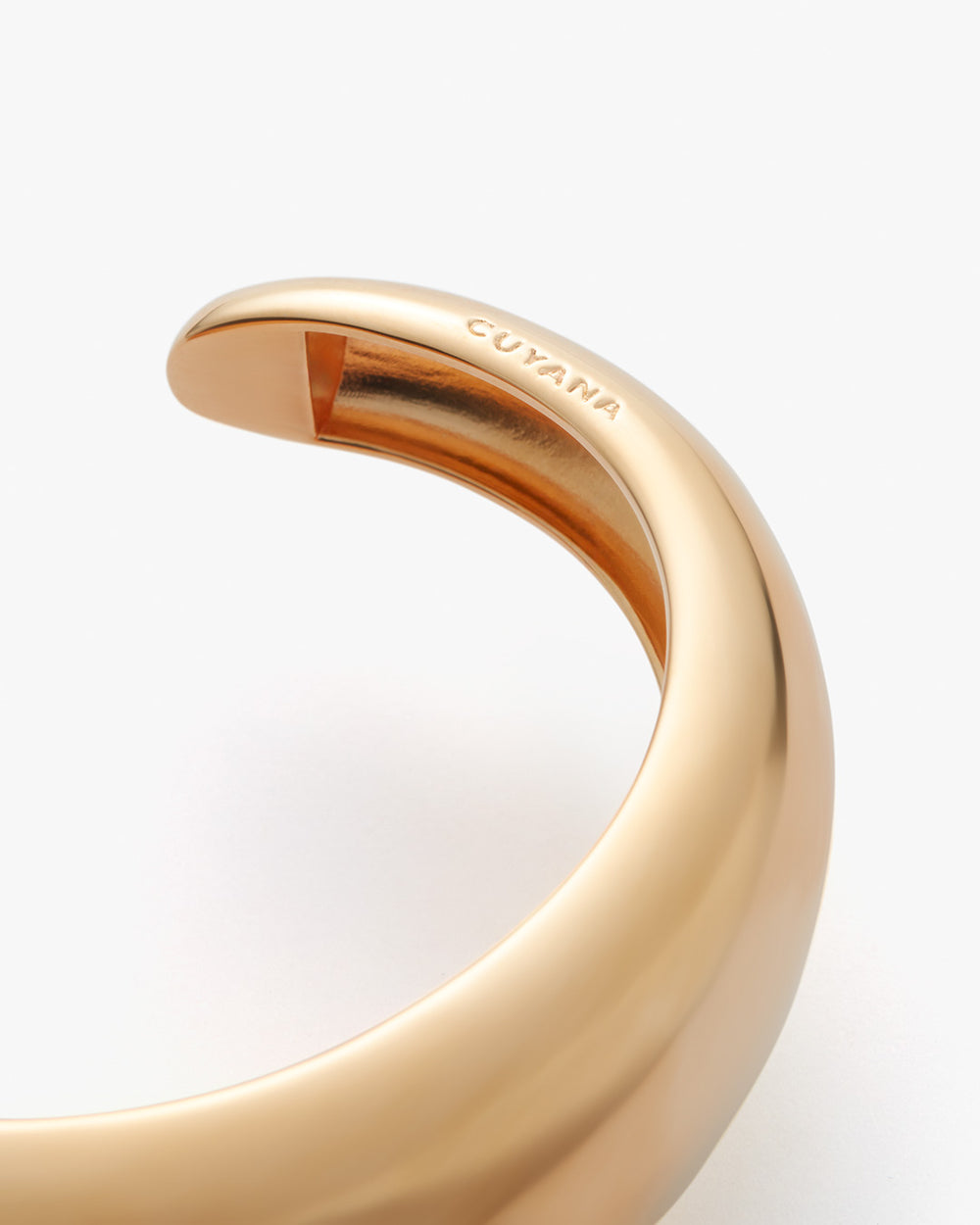 Close-up view of a curved bracelet with a brand name inscription.