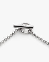 Metal chain with a circular clasp and brand name inscribed.