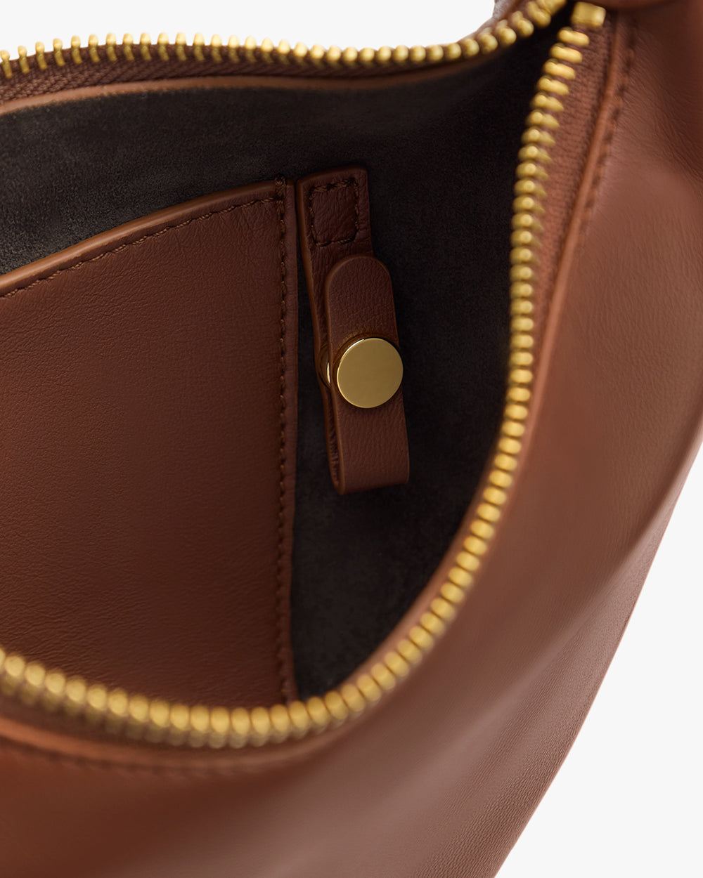 Open handbag with zipper and interior pocket with snap closure.