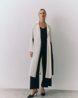 Person wearing long coat over outfit with heels.