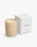 Candle beside its box with brand name and text visible.