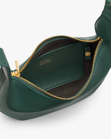 Open handbag with gold zipper showing a small interior pocket.
