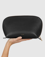 A hand holding a small zippered pouch.