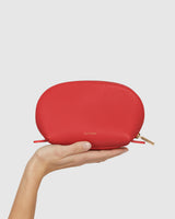 Hand holding a small zippered pouch.