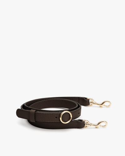 Adjustable bag strap with gold clips on each end.