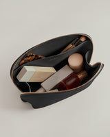 Open pouch with cosmetics and brushes inside