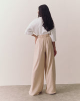 Person in a white top and wide-leg pants, viewed from the back.