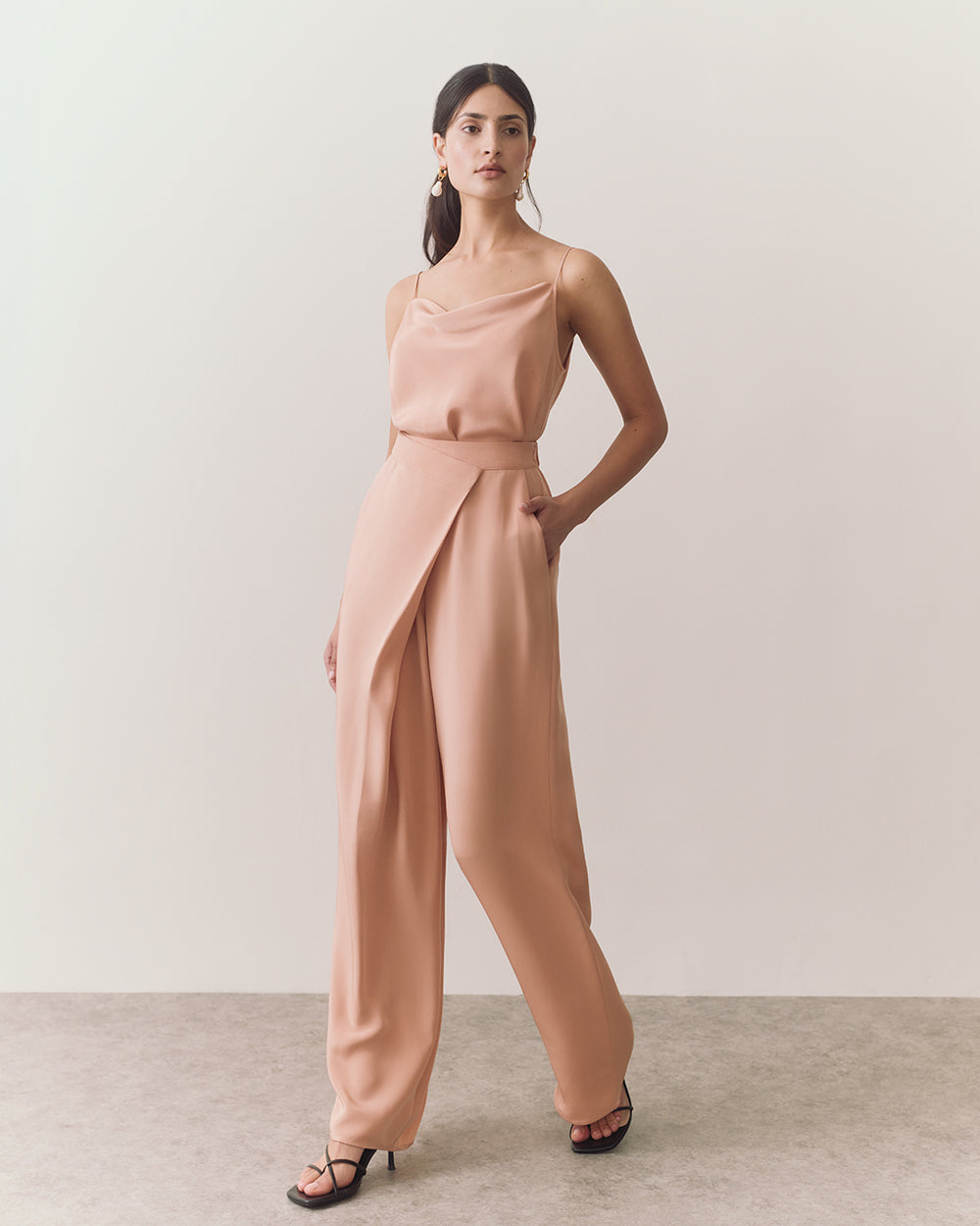 Woman walking in sleeveless top and wide-leg pants.