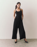 Person in a sleeveless jumpsuit standing in a neutral pose