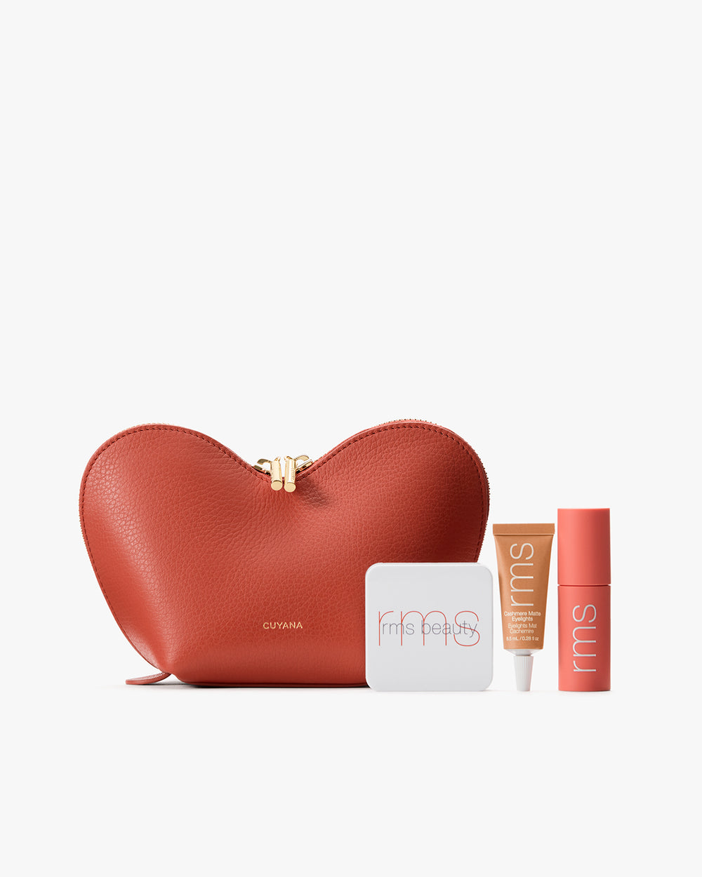 Heart-shaped pouch next to a tube of lip oil, a blush compact, and a cream eyeshadow.