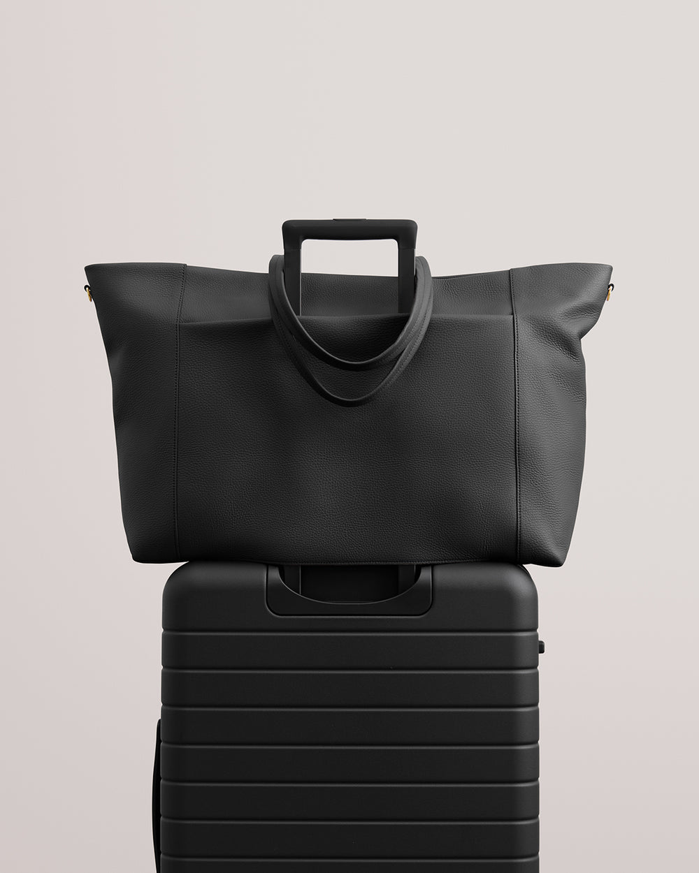 Travel bag resting on rolling luggage