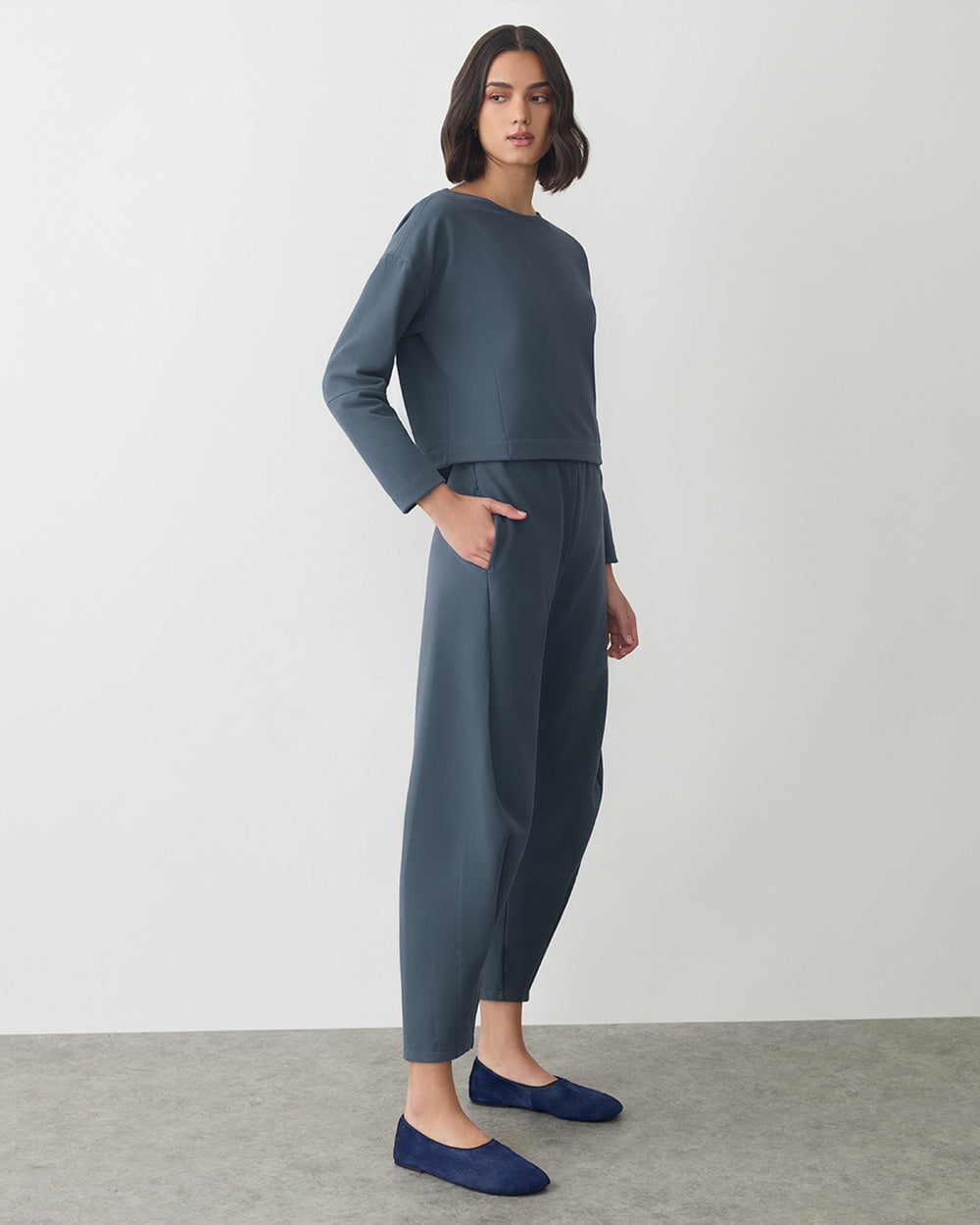 Person wearing a matching set with long sleeves and pants, standing on a plain background.