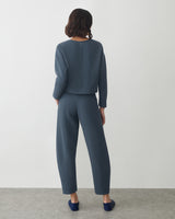 Person wearing a matching top and pants, standing with back facing the camera.