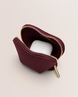 Pouch with a zipper partially open showing wireless earbuds inside.