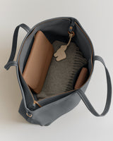 Open travel bag with items inside including a laptop sleeve and pouch.