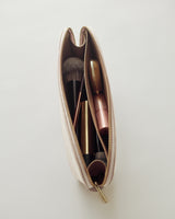 Cosmetic bag with makeup brushes and lipstick inside.